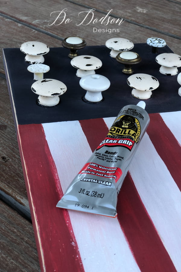 Mismatched knobs on a DIY wooden American Flag sign for the 4th of July porch decorations.
