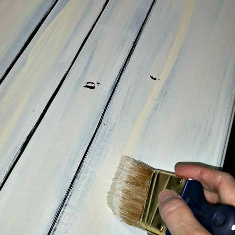 The next step is to paint over the stain on the faux plank farmhouse kitchen table to create a vintage painted look.