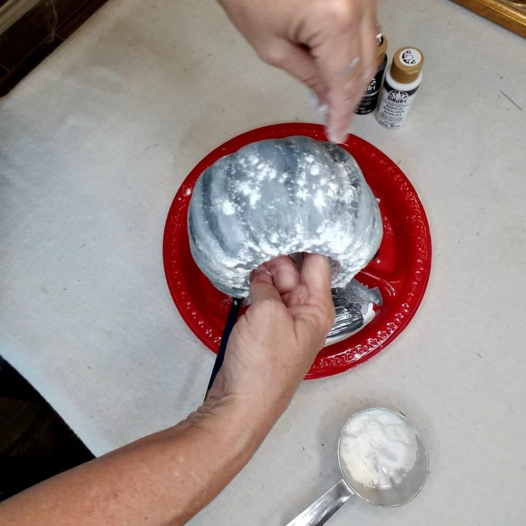 I sprinkled flour over the wet paint on the dollar tree pumpkin to create a concrete look.