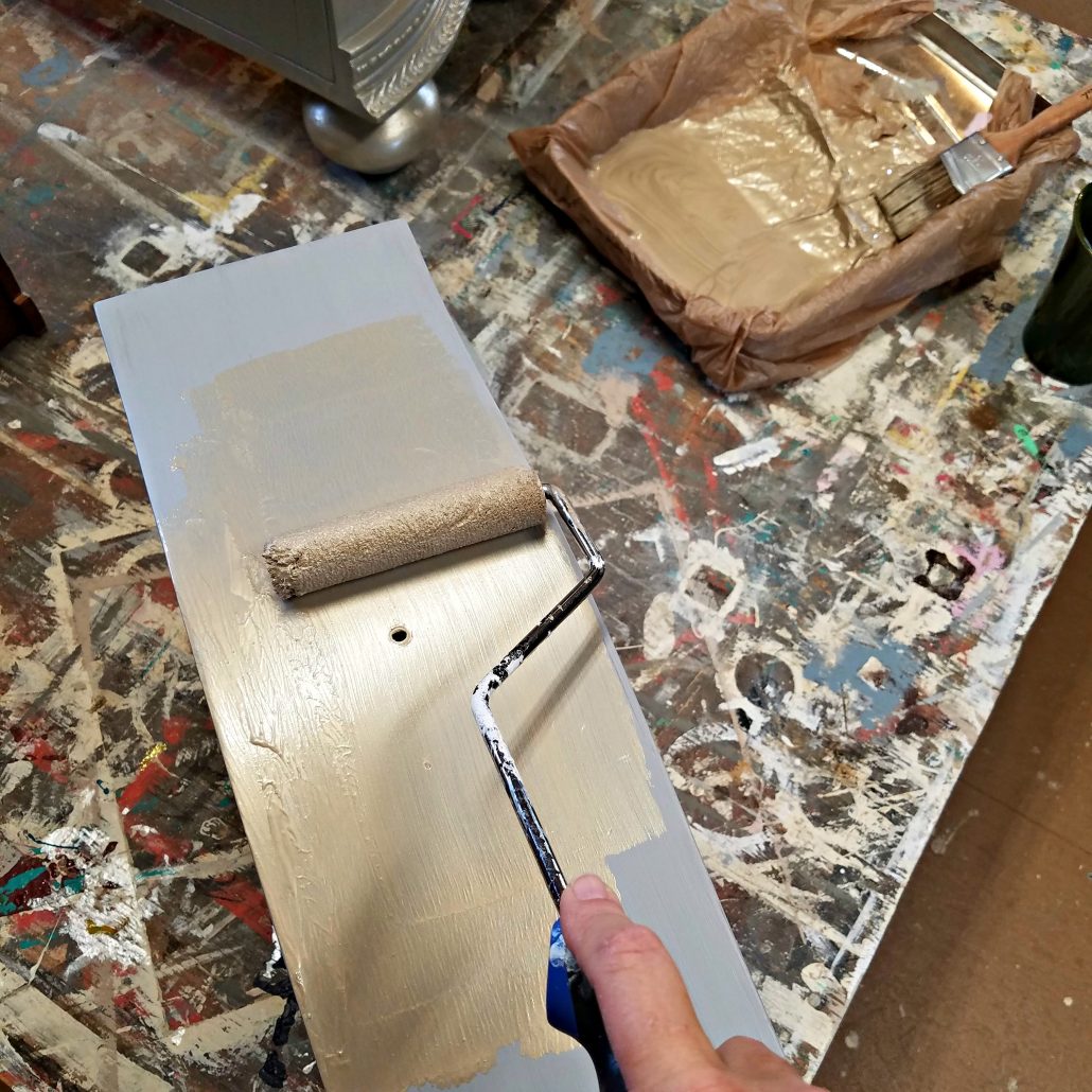 Roll your metallic paint over your furniture first. Then go back with a good synthetic paintbrush to smooth it out.