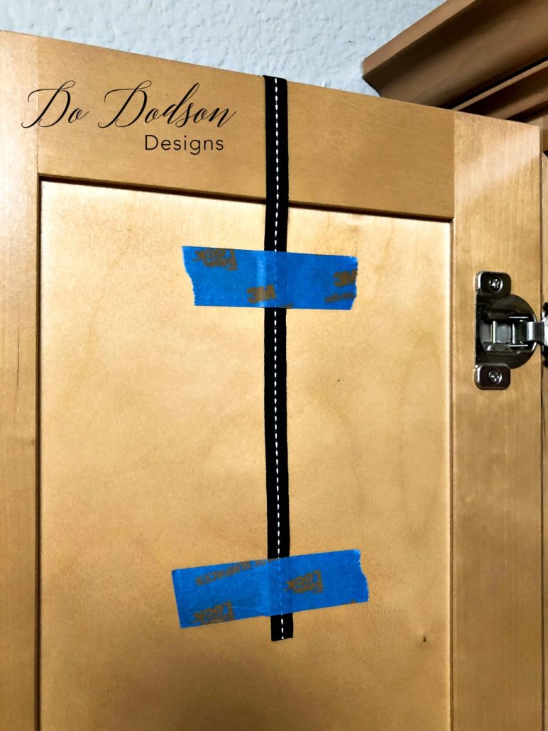 Secure Mini Wreaths to the back of cabinet doors with painters tape.