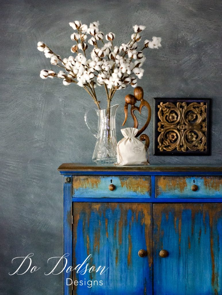 Secondhand furniture chest painted in layered blue and gray with an authentic rust patina finish.