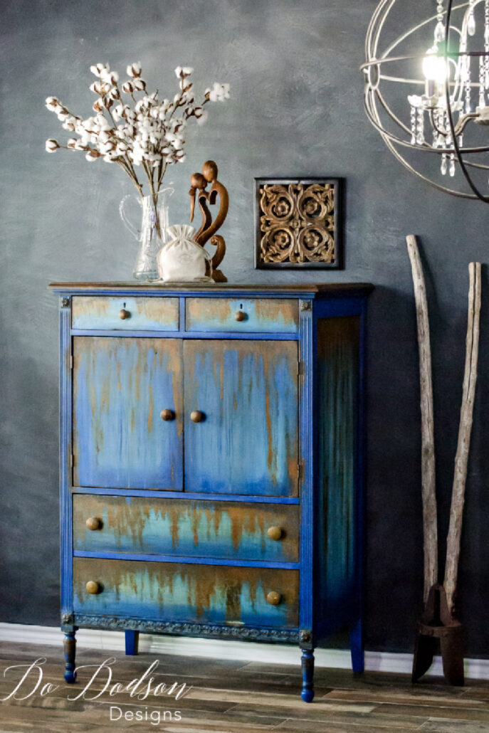 Secondhand furniture chest painted in layered blue and gray with an authentic rust patina finish.