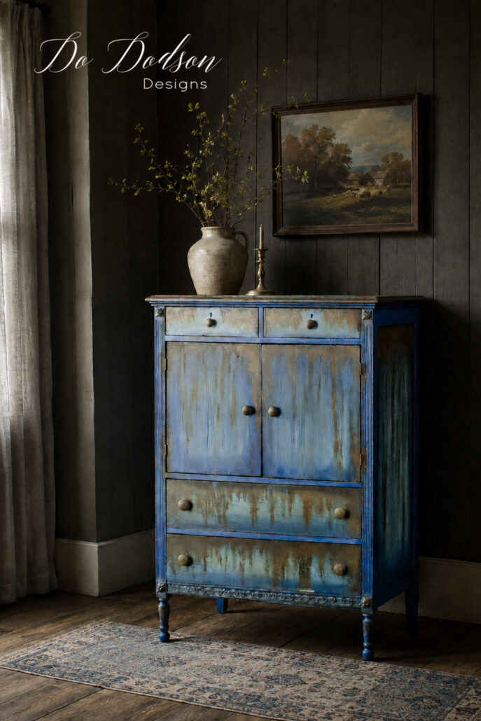 Blue rust-patina chest styled in a moody farmhouse room with charcoal paneled walls and a faded blue vintage rug.