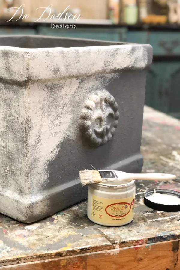 After the base coat of chalk paint is dried I added a second color to create a concrete look on my terracotta pots. I used a technique called stippling with my chip brush. Apply a small amount on the tip of the bristles of the brush and dab it on with an up and down motion instead of the back and forth. You don't want full coverage on this step. 