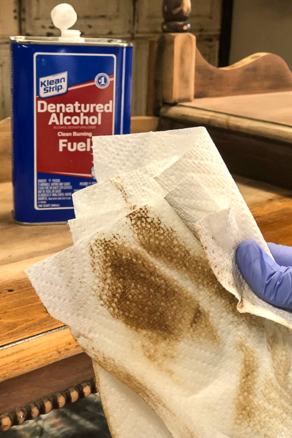Denatured alcohol was used to remove the leftover dust from sanding down to the barewood. It cleans and evaporates quickly so that I can move to the next step in creating a raw wood furniture finish on this old piece.