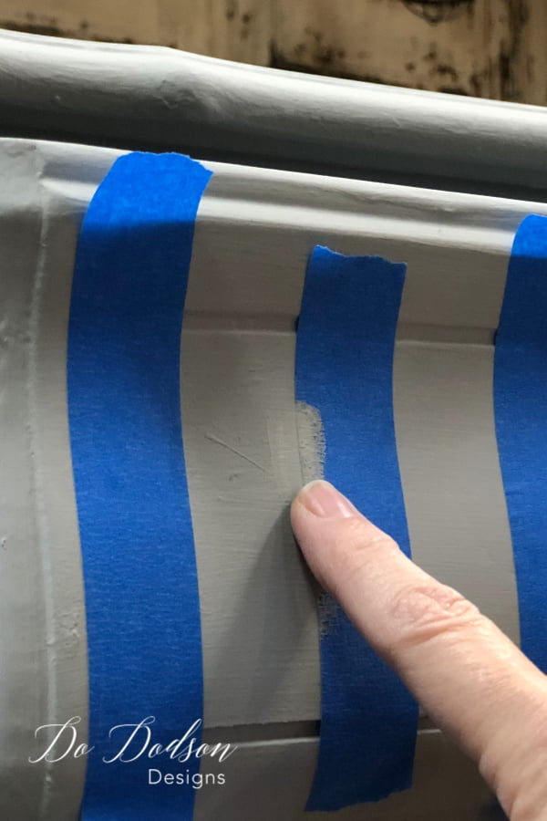 Using my finger, I carefully painted a small amount over the tapes edge with the same base coat color. This will prevent bleeding when I paint the stripes. This method is called paint burnishing and even the best chalk paint will bleed if you skip this step.