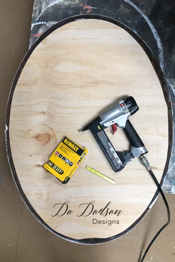 The backing was secured with staples to hold the reclaimed wood in place on the mirror frame.