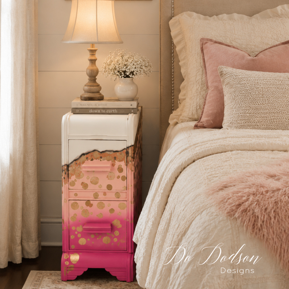 DIY painted whimsical nightstand with a pink ombré finish and gold polka dot details styled beside a cozy neutral bed.