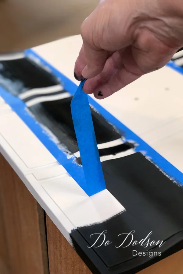 Next, paint the color of your choice for the stripes on furniture. If you're using a black over white like I'm doing here, you're probably gonna need a second coat of paint for full coverage.