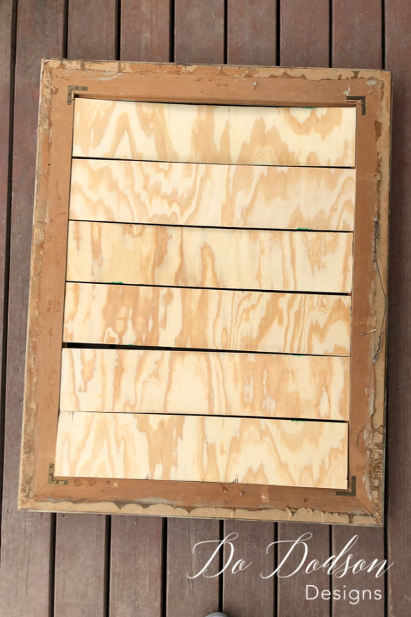 Upcycle picture frames with plywood to create faux shiplap wall decor.