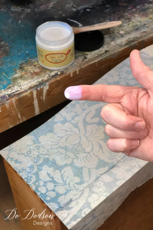 Use a small amount of the top coat on the tip of your finger to smooth any bubbles and tiny lines for a beautiful finish on your decoupage furniture project