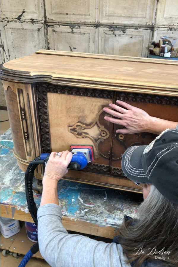 I started this furniture makeover by sanding down the old varnish to reveal all the beautiful wood. The black wax will compliment the wood nicely.