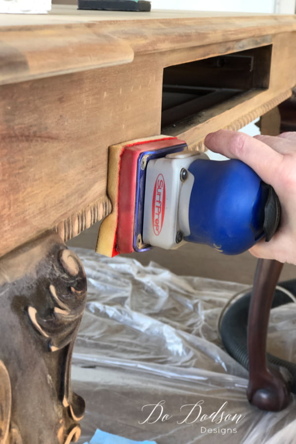 Next, sand the wood to remove any leftover varnish. I use a sander that has padded sandpaper that's great for getting into the detailed wood trim and carvings. Clean the wood after sanding with a 50/50 mixture of denatured alcohol and water. The whitewash I'm using on the table top will look amazing!