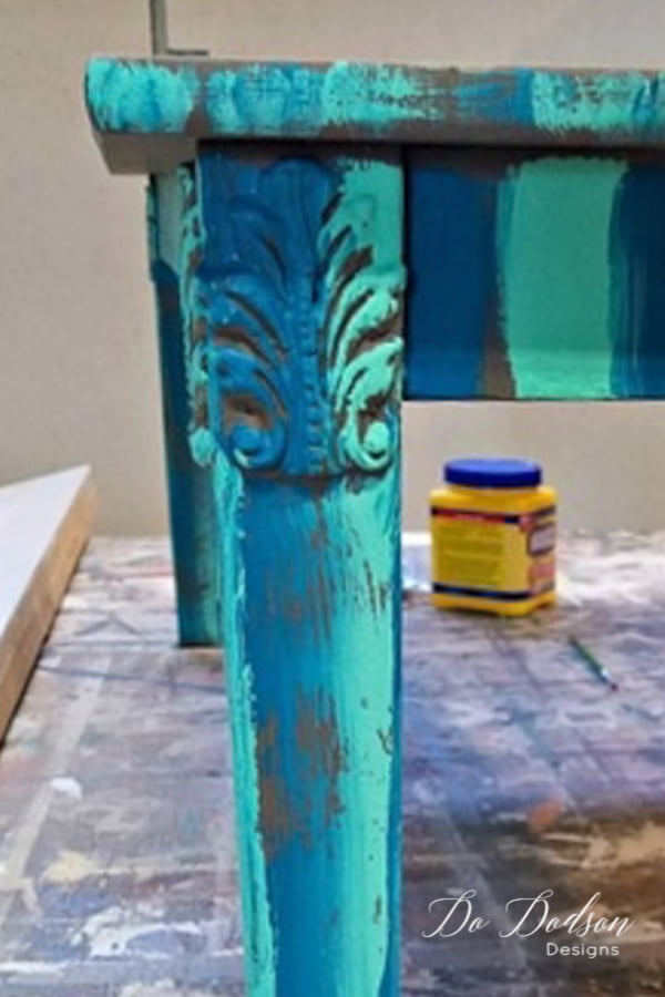 I used two other BOLD colors of Mint Julip and Mermaid Tail and painted bold stripes all around the table. It was pretty wild looking I have to admit, but I wanted a peek a boo effect to show through the last coat of paint. More or less, I just lightly brushed across the surface with a hit and miss leaving the base color showing.