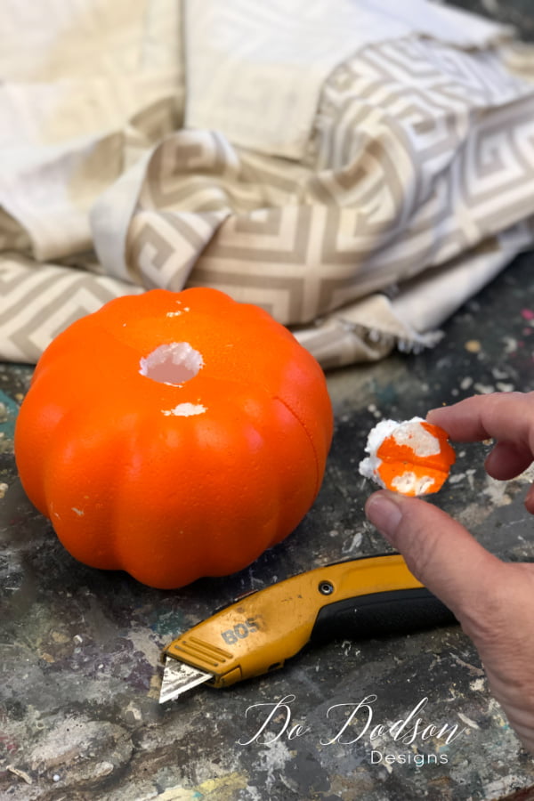 Cut a hole in the top of the Dollar Tree pumpkin. This is where the fabric will be inserted. 