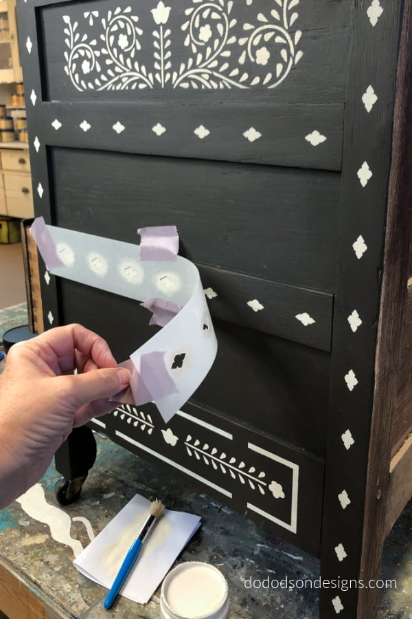 Carefully remove the bone inlay stencil from the dresser once the paint had been applied.