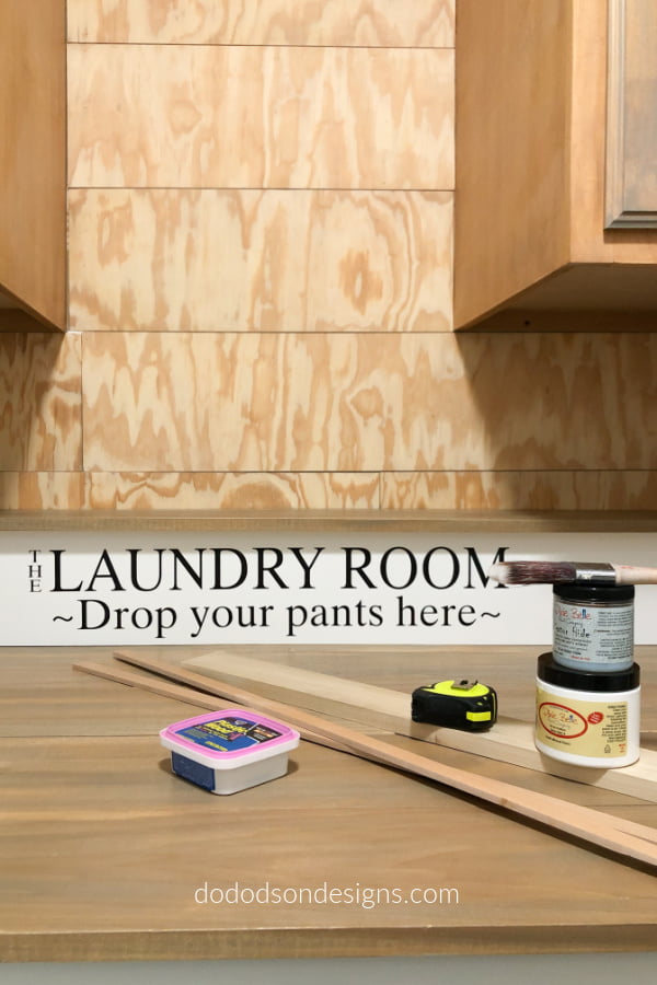 We added a faux shiplap wall over the folding station. This DIY laundry room makeover is starting to take shape in this small space.