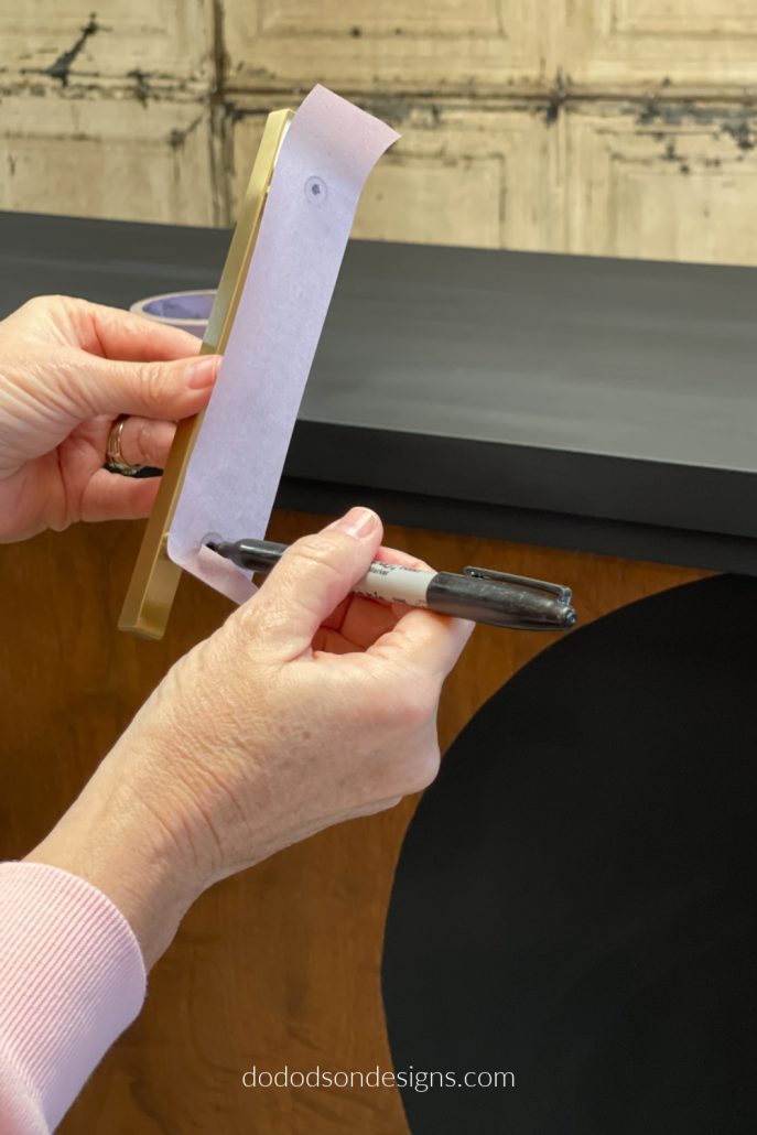Use a sharpie marker to mark the center of the screw holes. OMG! I know what you're thinking. Replacing hardware on a dresser is looking pretty easy right about now.