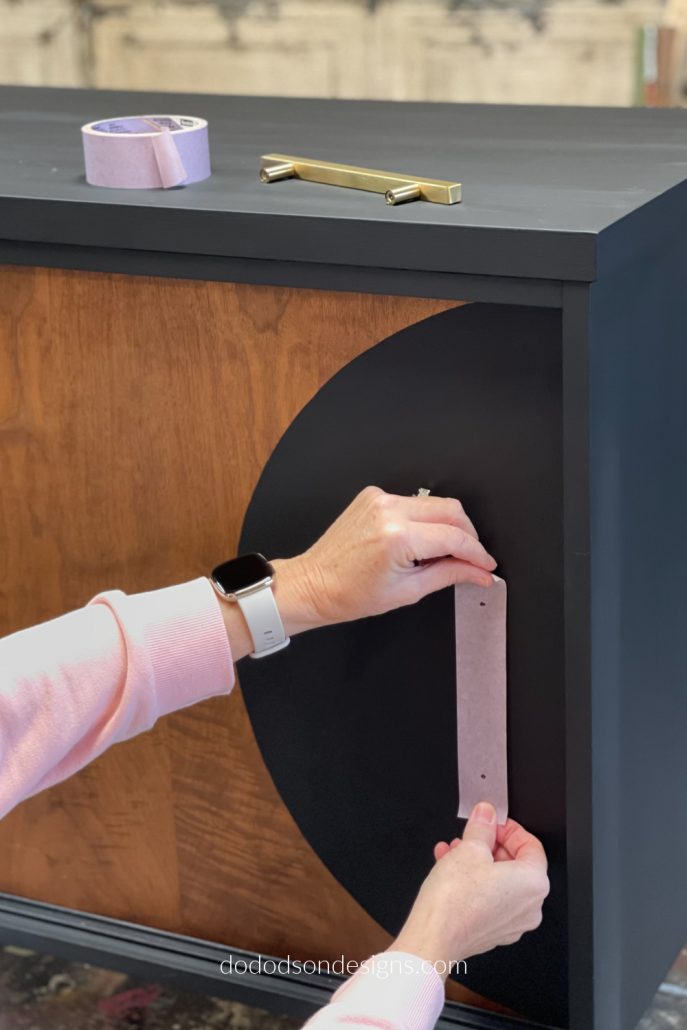 And lastly, place the painter's tape where you want the hardware to go on your dresser/cabinet. Mark the holes through the tape and proceed with drilling the perfect placement for your new hardware.