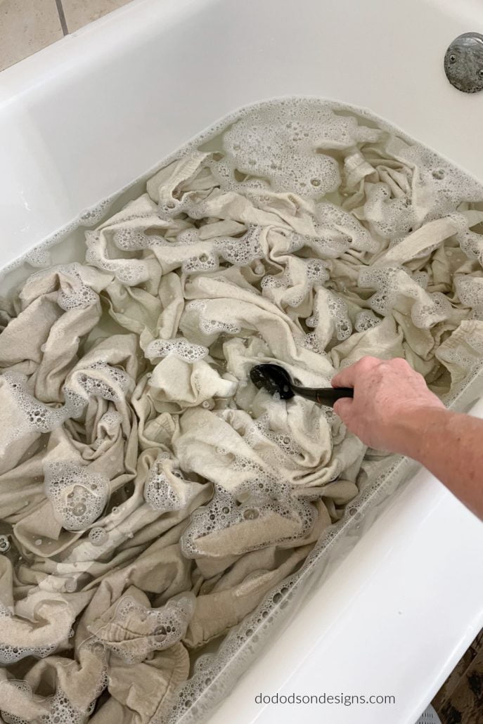 Add the drop cloths to the bleach water solution. Now the babysitting begins! You're going to stir the drop cloths every hour or so to ensure that all the fabric is covered for equal bleaching. It's the best way to bleach drop cloth for curtains!