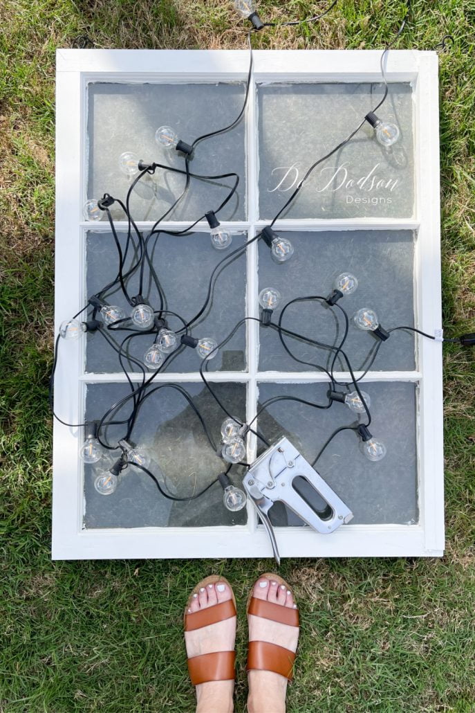 I added string lights to old windows for a unique light feature on my back patio.