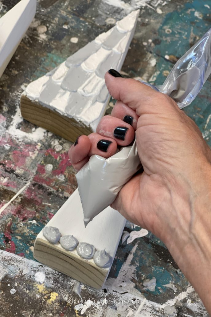 Here is the fun part! It may look like cake icing but it's not. It's paint icing and I'm decorating wood block Christmas trees with it.