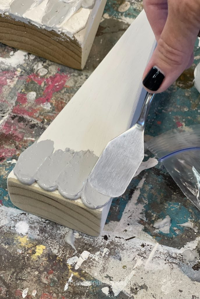 Here is the fun part! It may look like cake icing but it's not. It's paint icing and I'm decorating wood block Christmas trees with it.