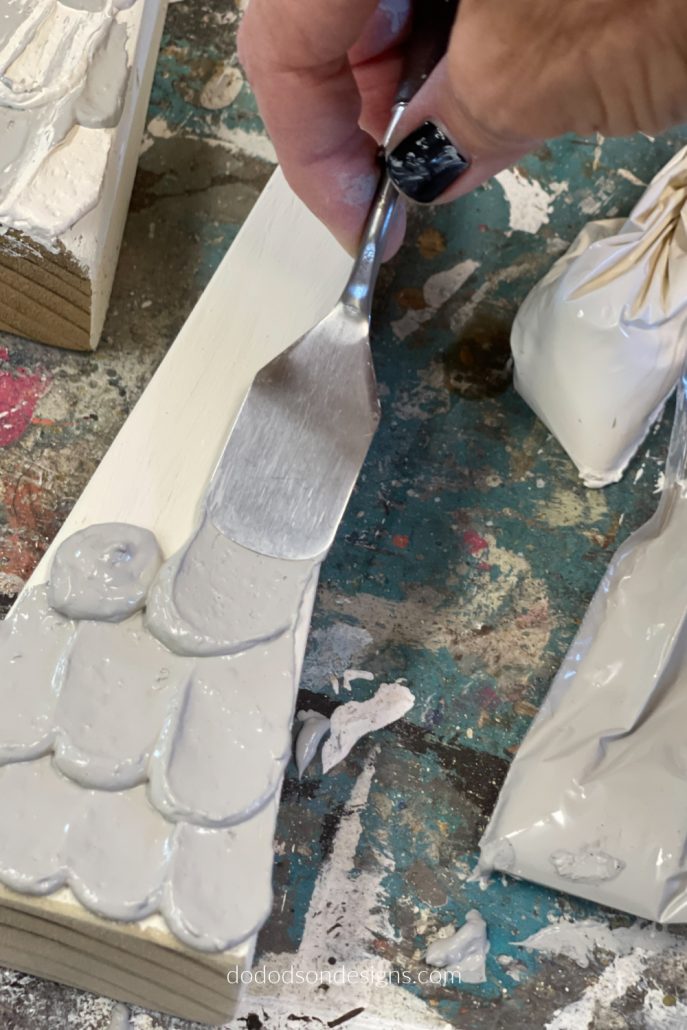 Here is the fun part! It may look like cake icing but it's not. It's paint icing and I'm decorating wood block Christmas trees with it.
