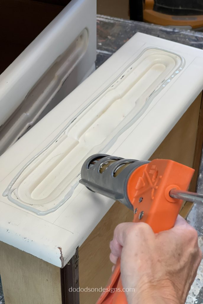 I used liquid nail adhesive to secure with plywood and trim around the drawer fronts to give them an much needed update. Best furniture makeover ever!