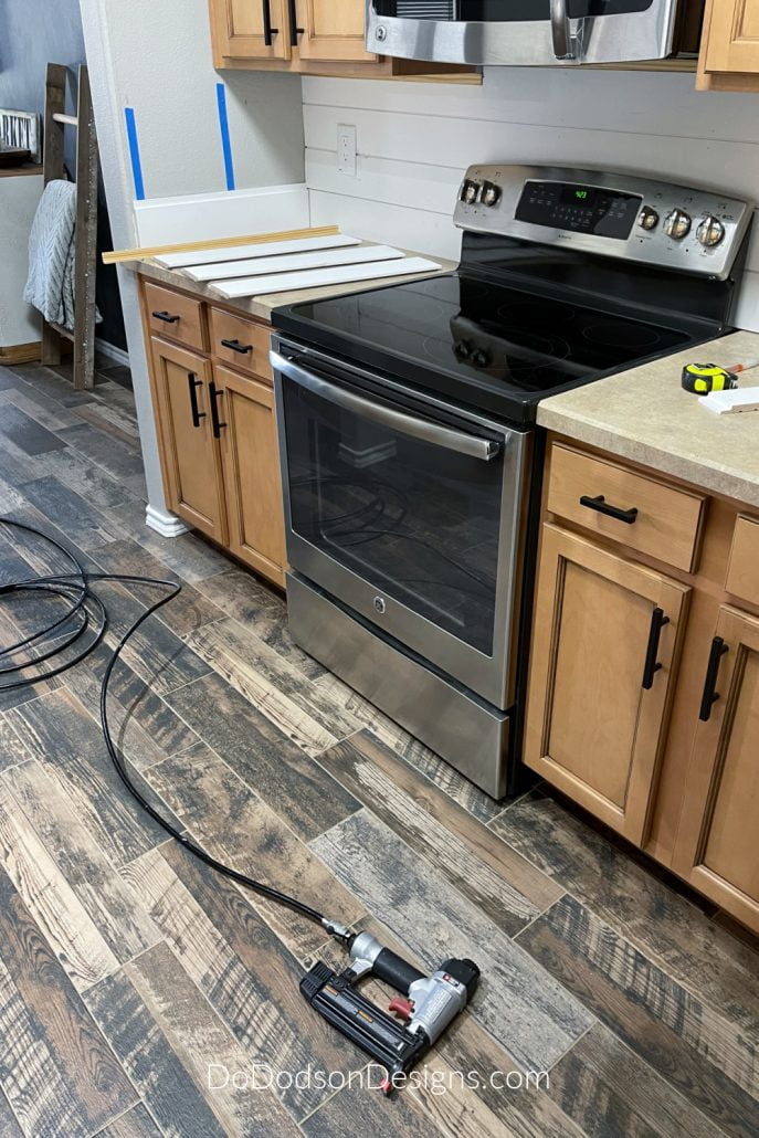 A pin nailer makes the installation of shiplap on a backsplash quick and easy.