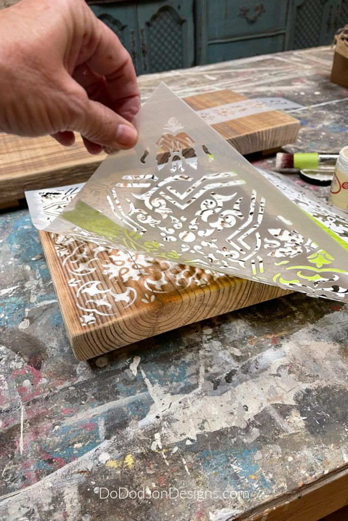 Lay the stencil over your DIY wood table riser. I used painter's tape to outline the section of the pattern I wanted to use. Doing this allows me to use these larger stencils on small projects.