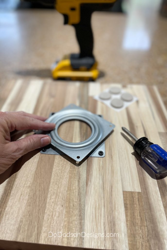 Attach the lazy susan rotating turntable hardware with the screws leaving the top part of the hardware free to rotate.