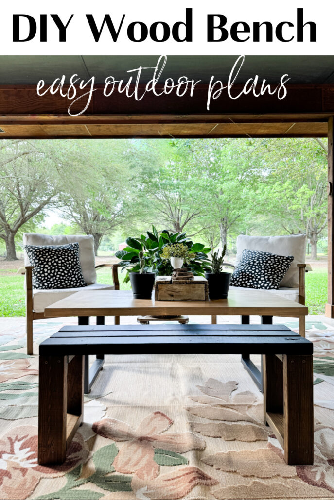 DIY wood bench with black slatted top and stained wood base, styled on a cozy outdoor patio with a coffee table, cushioned chairs, and greenery.