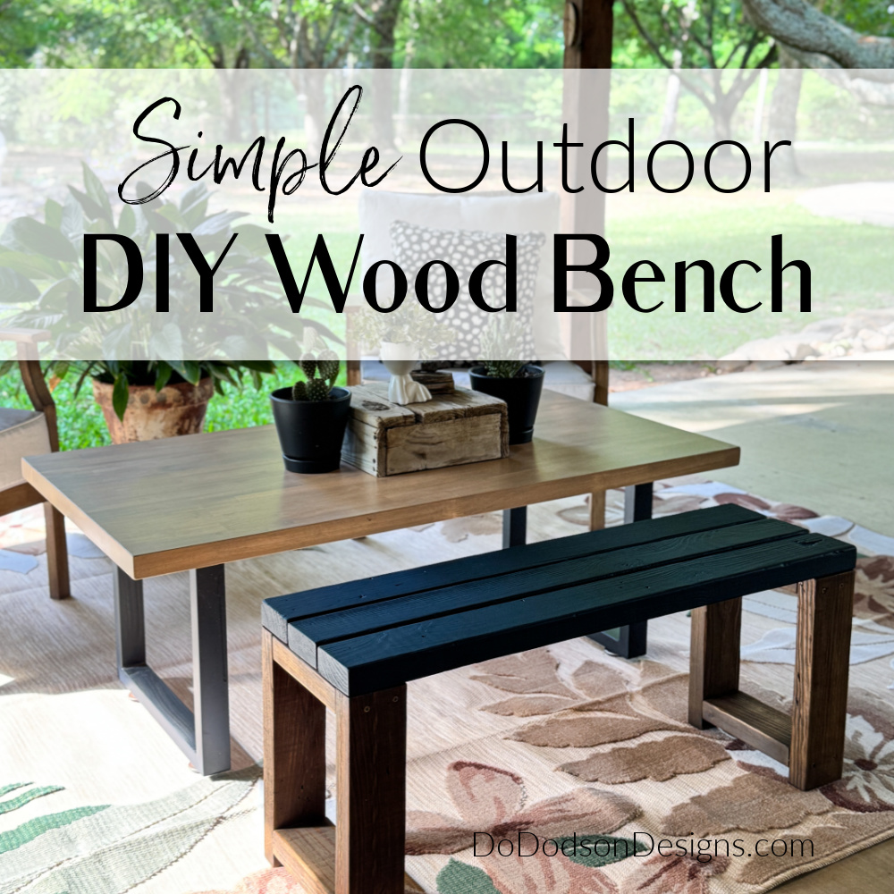 Simple outdoor DIY wood bench made from 2x4s with a black slatted seat and stained wood base, styled on a covered patio beside a coffee table and plants.