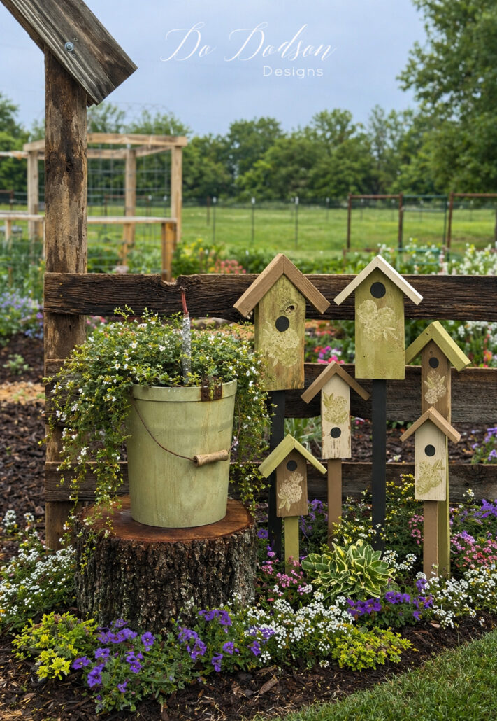 DIY decorative birdhouse stakes arranged in a backyard garden with flowers and a hanging planter, creating a beautiful cottage-style outdoor decor display.
