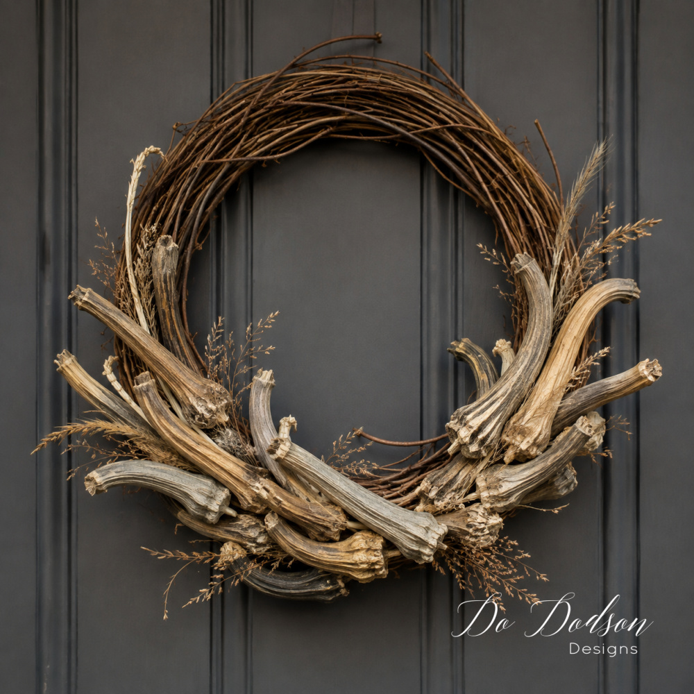 Fall wreath made with real dried pumpkin stems and delicate grasses on a dark charcoal farmhouse door.