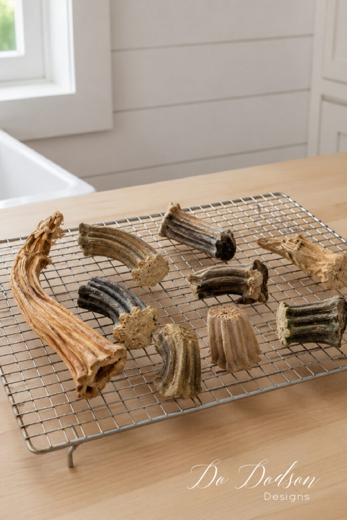 Real pumpkin stems drying in a single layer on a raised wire rack in a bright farmhouse kitchen.
