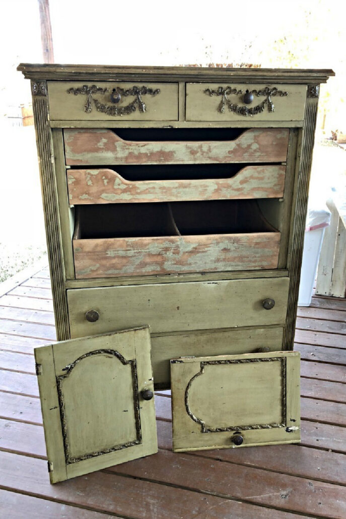 Dirty green secondhand cabinet with damaged drawers and removed doors before its Green Goddess furniture makeover.