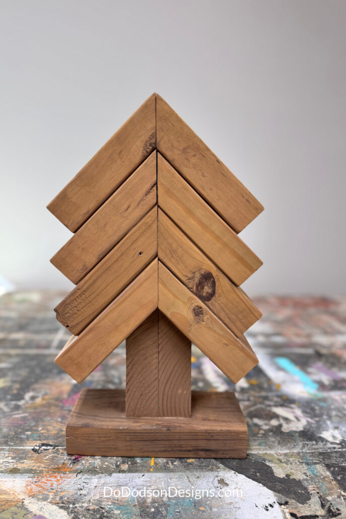 Medium 2x4 scrap wood Christmas tree with four tiers, a two-piece trunk, and a rectangular wood base
